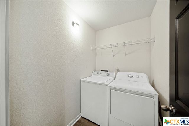 clothes washing area with separate washer and dryer and a textured ceiling