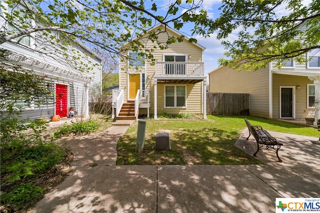 back of house featuring a balcony, a yard, and a patio area