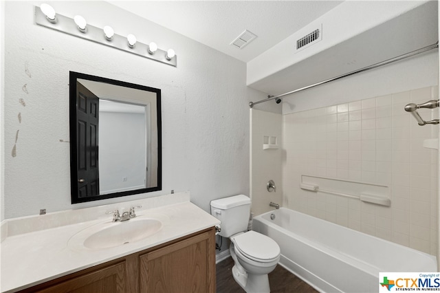 full bathroom with toilet, vanity, tiled shower / bath, and a textured ceiling