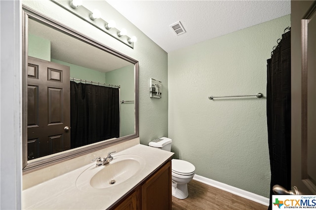 bathroom featuring vanity, a textured ceiling, hardwood / wood-style floors, curtained shower, and toilet