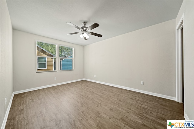 unfurnished room featuring dark wood-type flooring and ceiling fan