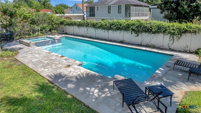 view of pool with an in ground hot tub, a patio, and a sunroom