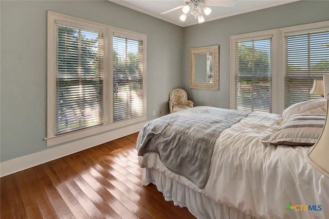 bedroom with ceiling fan, wood-type flooring, and ornamental molding