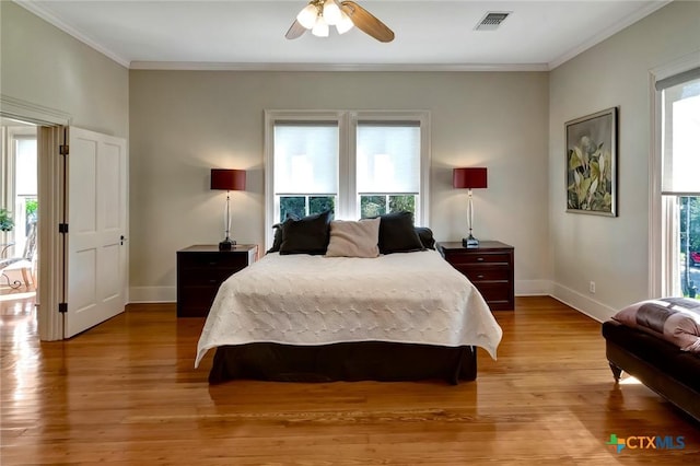 bedroom with ceiling fan, ornamental molding, multiple windows, and light hardwood / wood-style flooring