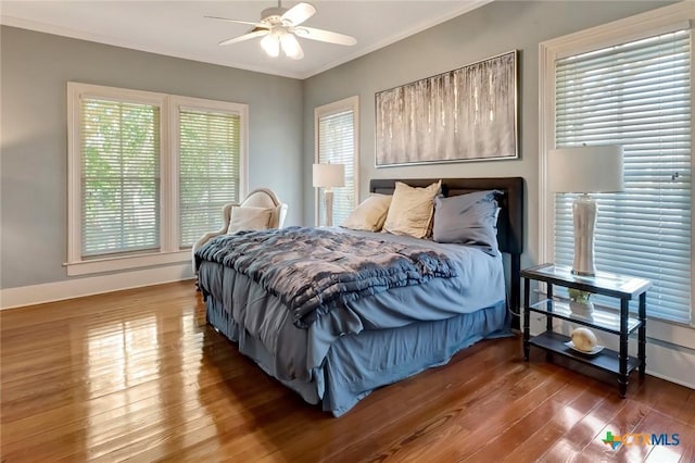 bedroom featuring ceiling fan, crown molding, and dark wood-type flooring