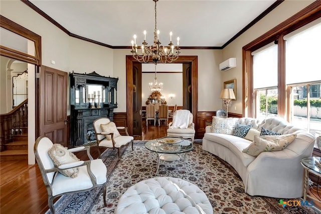 living room with a chandelier, wood-type flooring, an AC wall unit, and ornamental molding