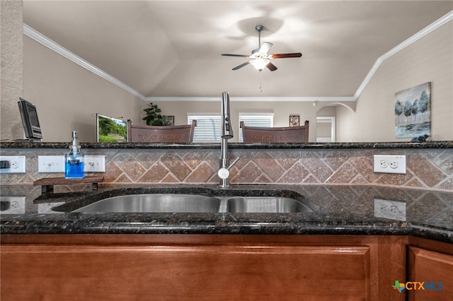 kitchen with lofted ceiling, dark stone counters, sink, and ceiling fan