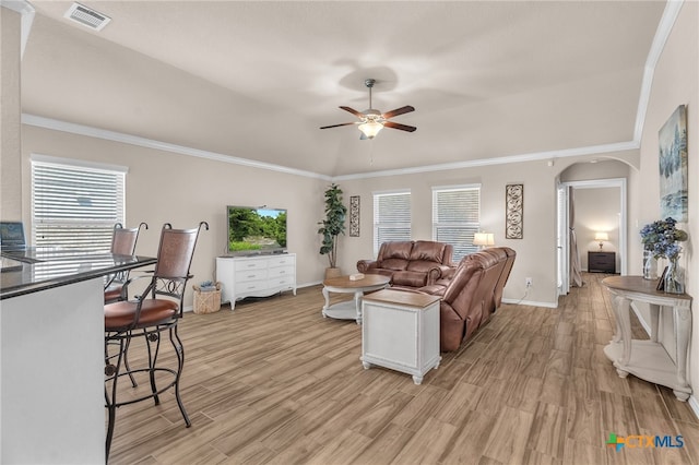 living room featuring vaulted ceiling, ceiling fan, light hardwood / wood-style flooring, and crown molding