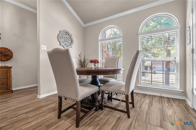 dining space featuring light wood-type flooring and crown molding