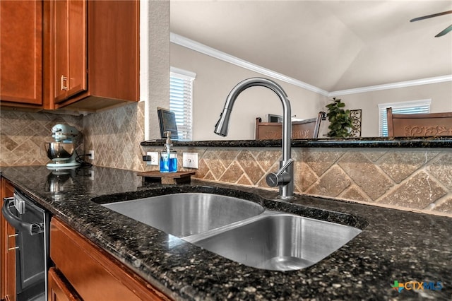 interior space with crown molding, dark stone counters, decorative backsplash, sink, and vaulted ceiling