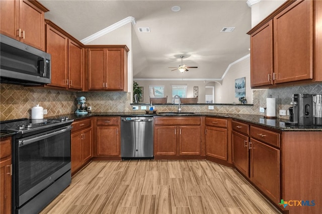 kitchen featuring stainless steel appliances, light hardwood / wood-style floors, sink, ornamental molding, and decorative backsplash