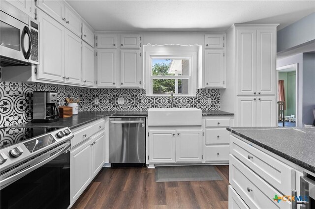 4007 Austin Ave, Waco, TX 76710 - kitchen featuring appliances with stainless steel finishes, dark countertops, white cabinets, and backsplash