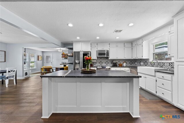 4007 Austin Ave, Waco, TX 76710 - kitchen with stainless steel appliances, a center island, dark countertops, white cabinetry, and recessed lighting
