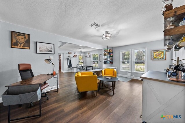4007 Austin Ave, Waco, TX 76710 - living area featuring dark wood finished floors, a textured ceiling, and a desk