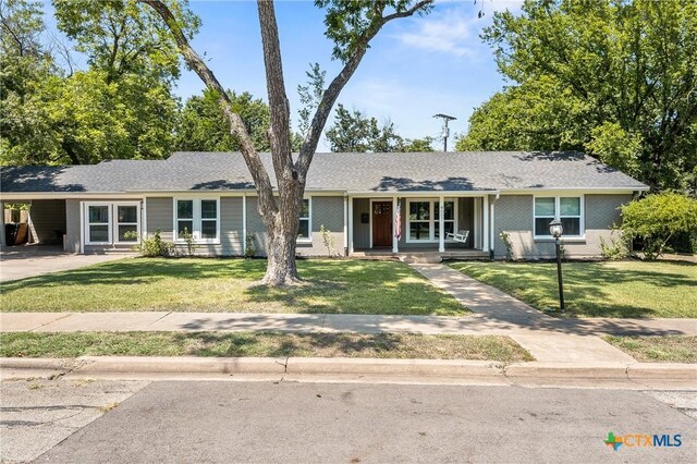 4007 Austin Ave, Waco, TX 76710 - ranch-style home with a porch, a front lawn, a carport, and driveway