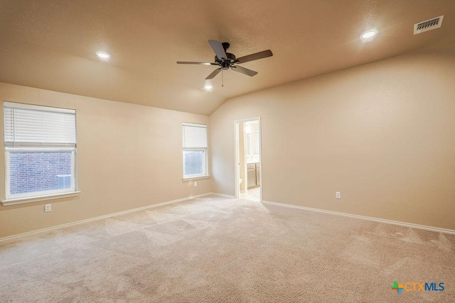 carpeted spare room with ceiling fan and lofted ceiling