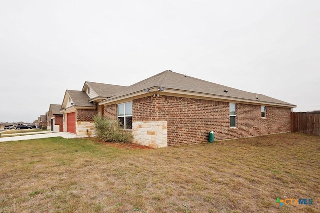 view of side of property featuring a garage and a yard