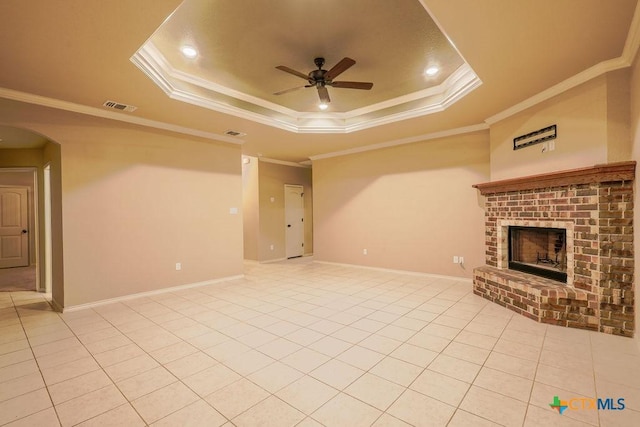 unfurnished living room featuring a raised ceiling, ceiling fan, light tile patterned flooring, and ornamental molding