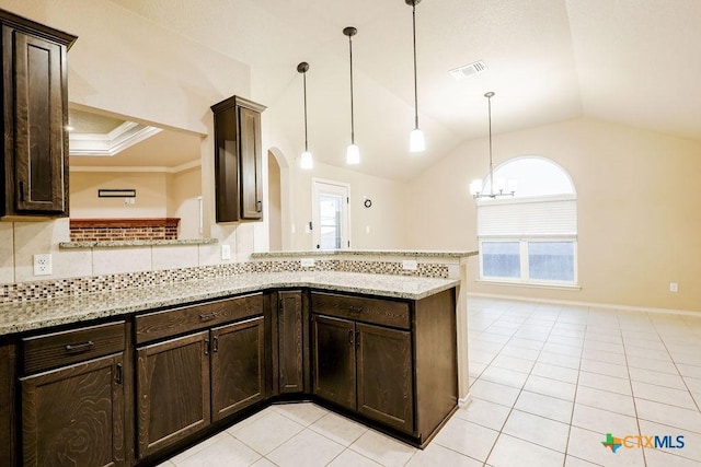 kitchen with hanging light fixtures, kitchen peninsula, and light stone countertops