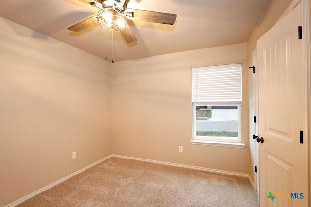 carpeted spare room featuring ceiling fan