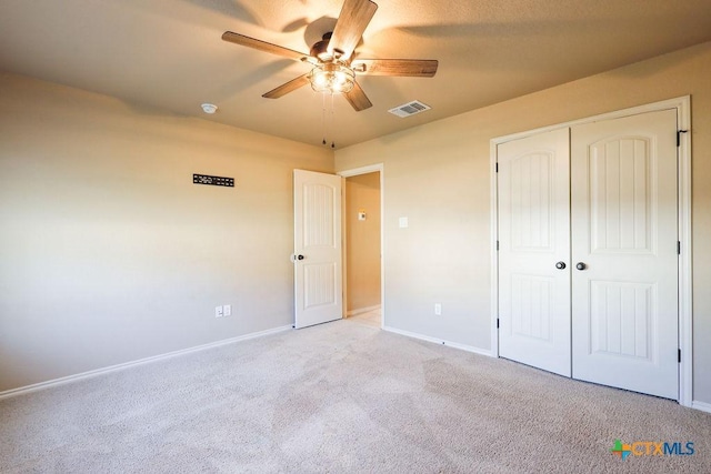 unfurnished bedroom featuring light carpet, ceiling fan, and a closet