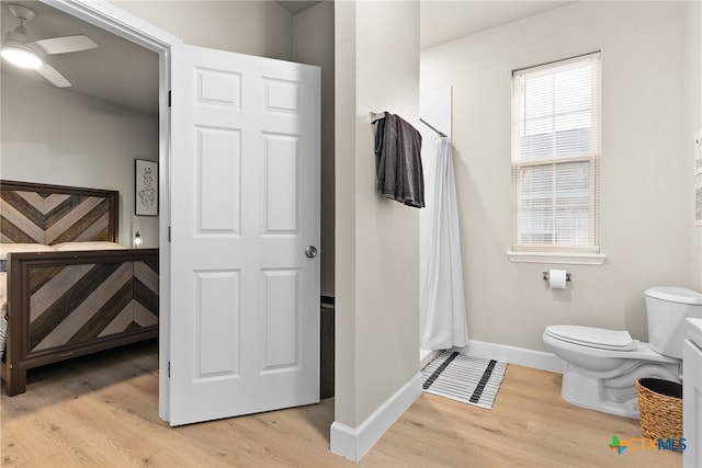 bathroom with wood-type flooring, toilet, and ceiling fan