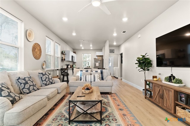 living room featuring light wood-type flooring and ceiling fan