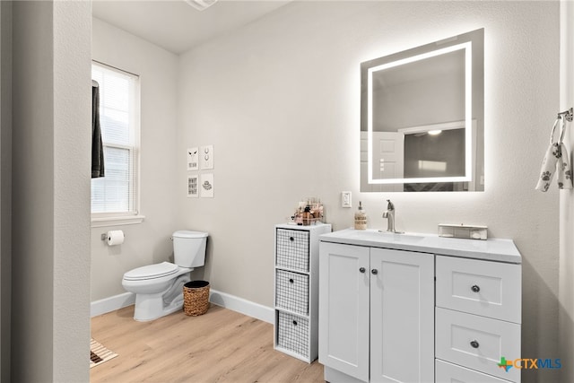 bathroom with hardwood / wood-style floors, vanity, and toilet