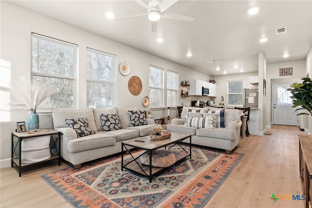 living room with ceiling fan and light hardwood / wood-style floors