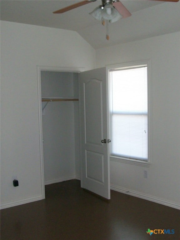 unfurnished bedroom with ceiling fan, a closet, and lofted ceiling