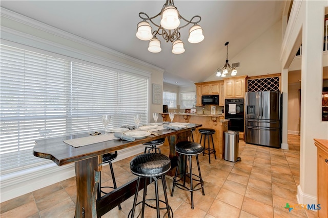 kitchen featuring a breakfast bar, black appliances, pendant lighting, light tile patterned floors, and an inviting chandelier