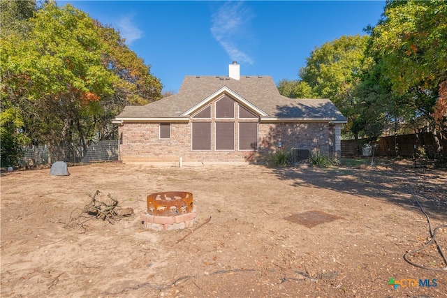 view of front of home with a fire pit and cooling unit