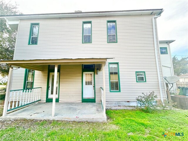 502 E Live Oak St, Cuero, TX 77954 - view of front of property with cooling unit, a front lawn, and a patio