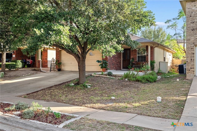 view of property hidden behind natural elements with central AC and a garage