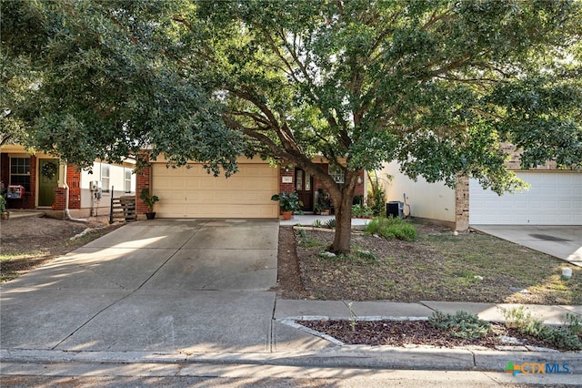 view of property hidden behind natural elements with a garage