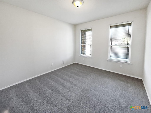 empty room featuring dark colored carpet