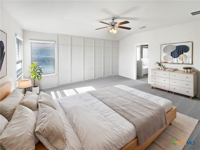 bedroom with ceiling fan, carpet floors, connected bathroom, and vaulted ceiling