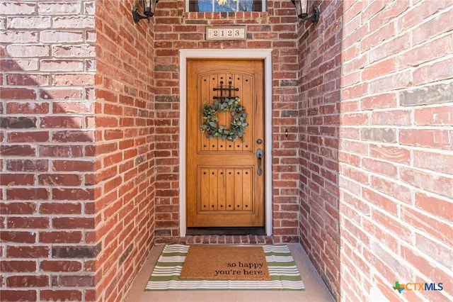 view of exterior entry with brick siding