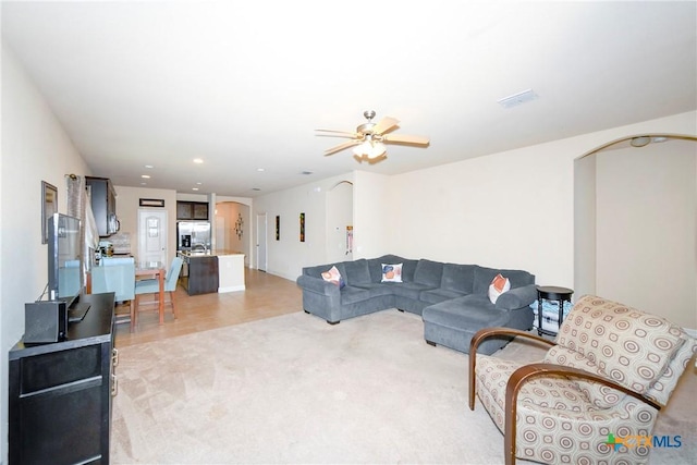 living room featuring light colored carpet and ceiling fan