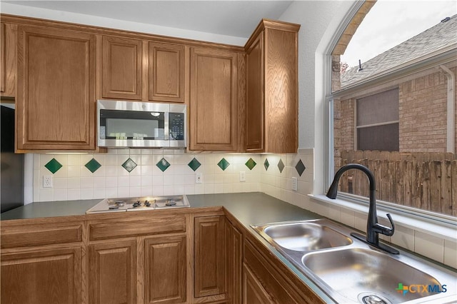 kitchen with decorative backsplash, sink, lofted ceiling, and appliances with stainless steel finishes