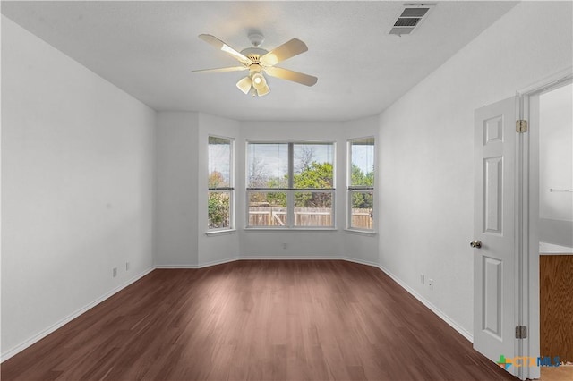 empty room with ceiling fan and dark hardwood / wood-style flooring