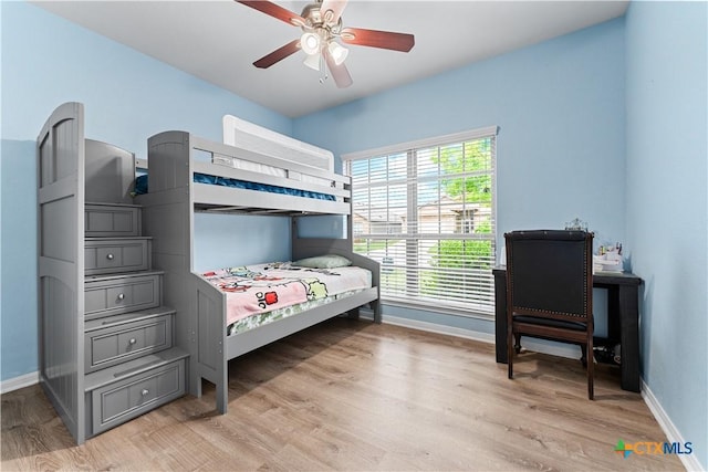 bedroom with light wood-style floors, baseboards, and ceiling fan