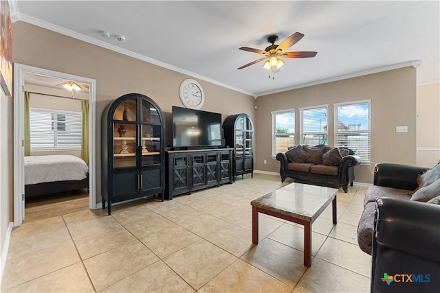 living area with light tile patterned floors, baseboards, ornamental molding, and a ceiling fan