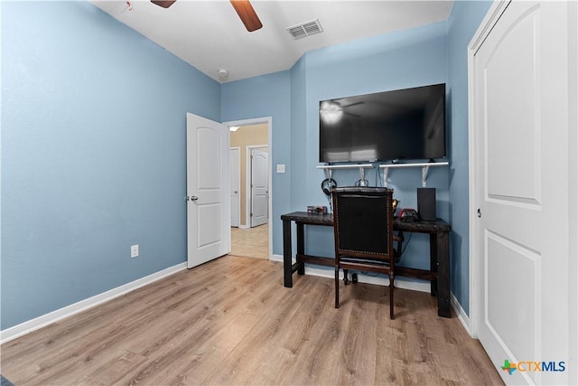 office with visible vents, a ceiling fan, baseboards, and wood finished floors