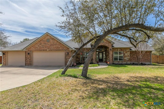 single story home with a garage, brick siding, concrete driveway, and a front yard