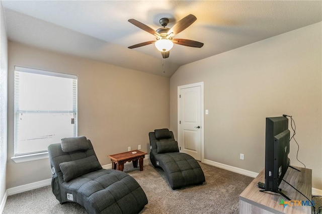 living area with baseboards, carpet, a ceiling fan, and vaulted ceiling