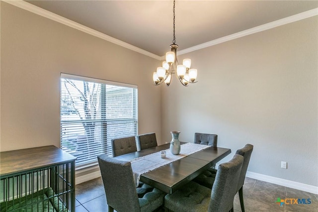 dining space featuring an inviting chandelier, dark tile patterned floors, crown molding, and baseboards