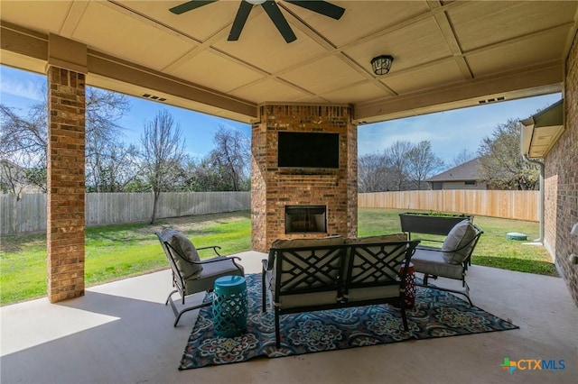 view of patio with an outdoor living space with a fireplace, ceiling fan, visible vents, and a fenced backyard