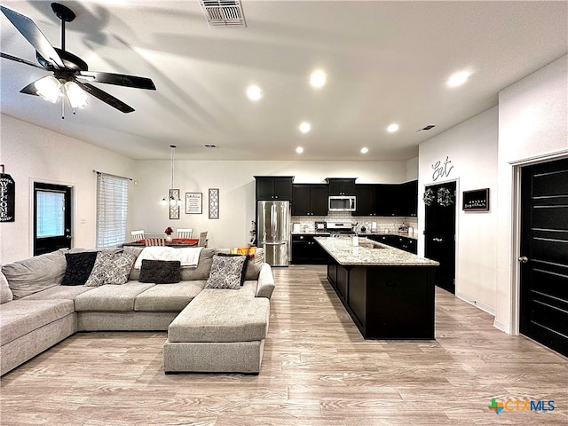 living room with light wood-type flooring and ceiling fan