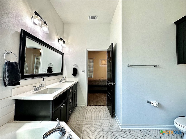 bathroom featuring vanity, tile patterned floors, and toilet